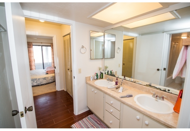 Both bedrooms are connected by a spacious bathroom with a dual vanity sink and a separate area for the toilet and shower.