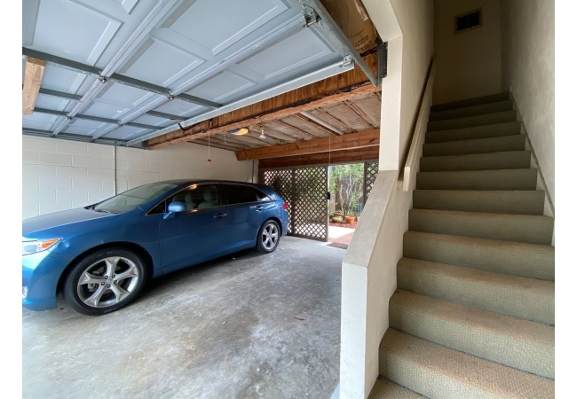 A view of the rear garage and stairs up to the studio.